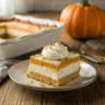 Slice of pumpkin lush dessert with layers of pumpkin pudding, cream cheese, and whipped topping