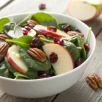 Fresh Spinach Apple Cranberry Salad in a white bowl