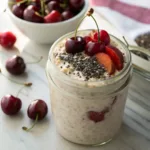 Glass jar of Cherry Overnight Oats with fresh cherries