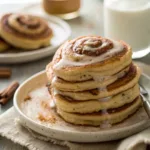 Stack of Cinnamon Roll Pancakes with creamy glaze and cinnamon sugar