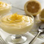 Glass of creamy Meyer Lemon Pudding garnished with lemon zest