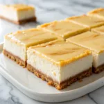 Creamy cheesecake bars sliced neatly on a platter