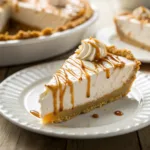 Slice of salted caramel cream pie topped with caramel drizzle and sea salt