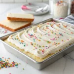 Frosted vanilla sheet cake topped with sprinkles