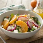 Fresh salad with mandarin segments, rainbow radishes, greens, and cheese
