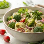 Broccoli pasta salad with tomatoes and creamy dressing in bowl