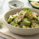 Cucumber avocado salad with herbs and lemon dressing in bowl
