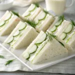 Cucumber sandwiches with cream cheese and dill on white plate
