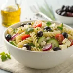 Greek pasta salad with olives, feta, cucumber, and tomatoes in bowl