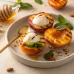 Grilled peaches topped with yogurt and honey on plate