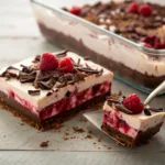 Layered raspberry chocolate dessert with whipped topping and berries
