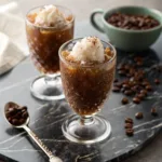 Espresso granita in glass cups topped with whipped cream and coffee beans