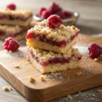Oat crumble bars filled with raspberry jam and powdered sugar