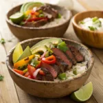 Steak fajita bowl with rice, peppers, onions, avocado, and lime