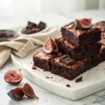 Homemade chocolate fig brownies with fudgy centers, fresh figs, and melted dark chocolate on a serving plate.
