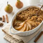 Homemade easy pear crisp with a golden oat crumble topping and tender cinnamon pears in a baking dish.