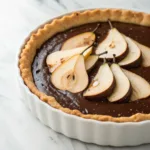 Chocolate pear tart with tender poached pears, rich chocolate filling, and a crisp buttery pastry crust.