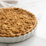Classic Dutch apple pie with cinnamon apples and a golden buttery crumb topping in a flaky crust.